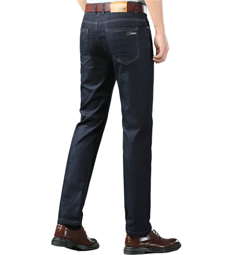 Dark blue jeans worn by a person on a gray background