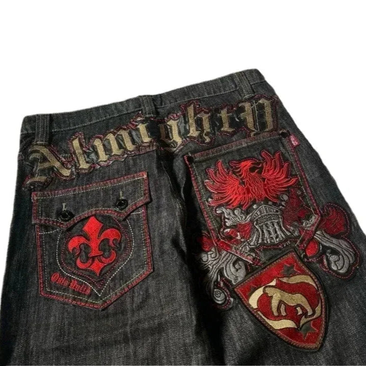 Dark denim shorts with embroidered designs and text on a white background