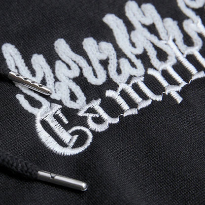 Black hoodie with white embroidered text and logo on a dark background