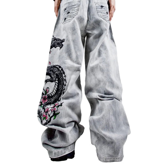 Light gray jeans with artistic designs on a plain background