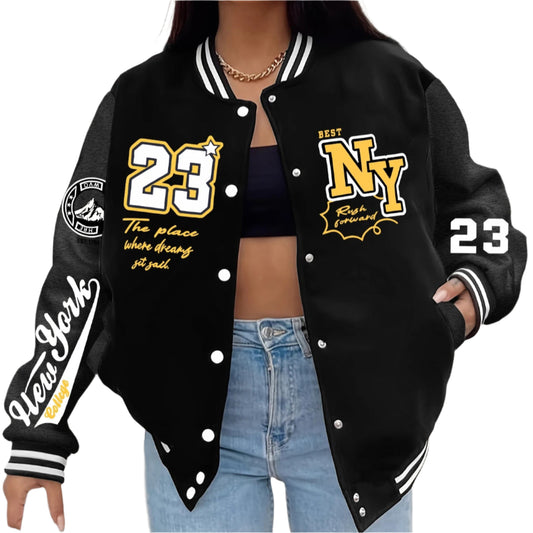 Person wearing a black varsity jacket with 'NY' and '23' branding, standing against a plain background.