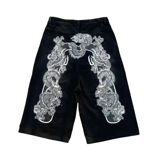 Black shorts with white embroidery on a concrete surface