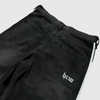 Black pants with a visible brand logo on a light gray background