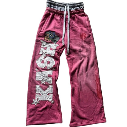 Pink sweatpants with branding on a textured surface