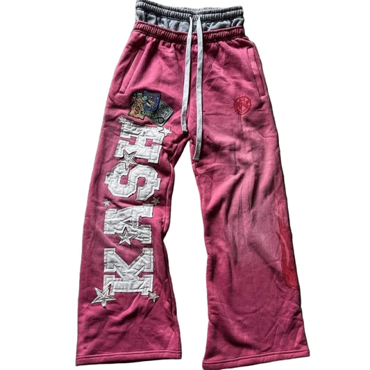 Pink sweatpants with branding on a textured surface