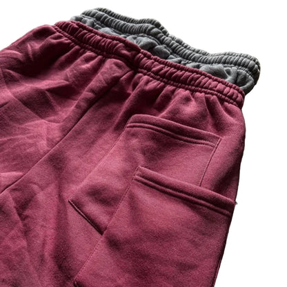 Maroon sweatpants with gray cuffs on a brown surface