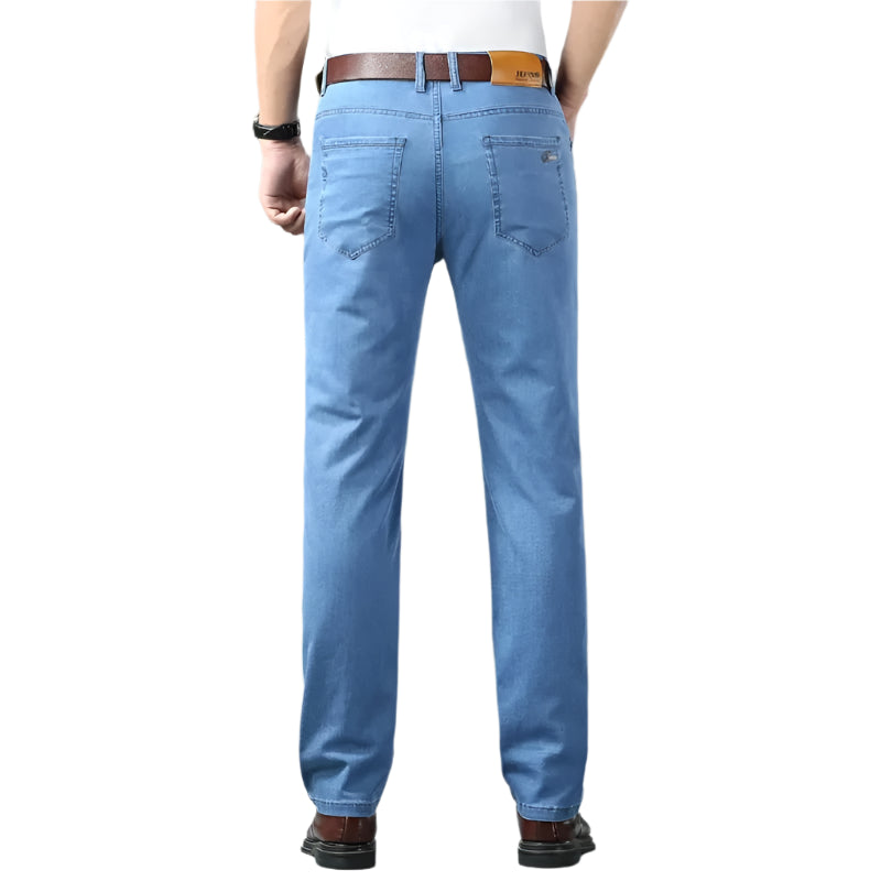 Person wearing blue jeans on a gray background