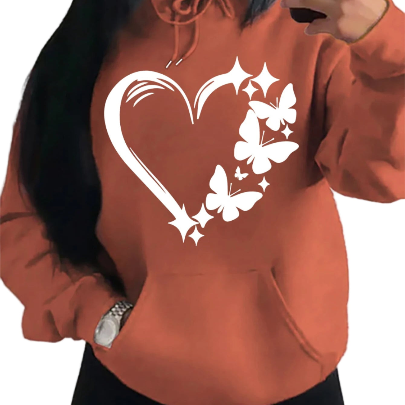 Person wearing an orange hoodie with a heart and butterfly design.