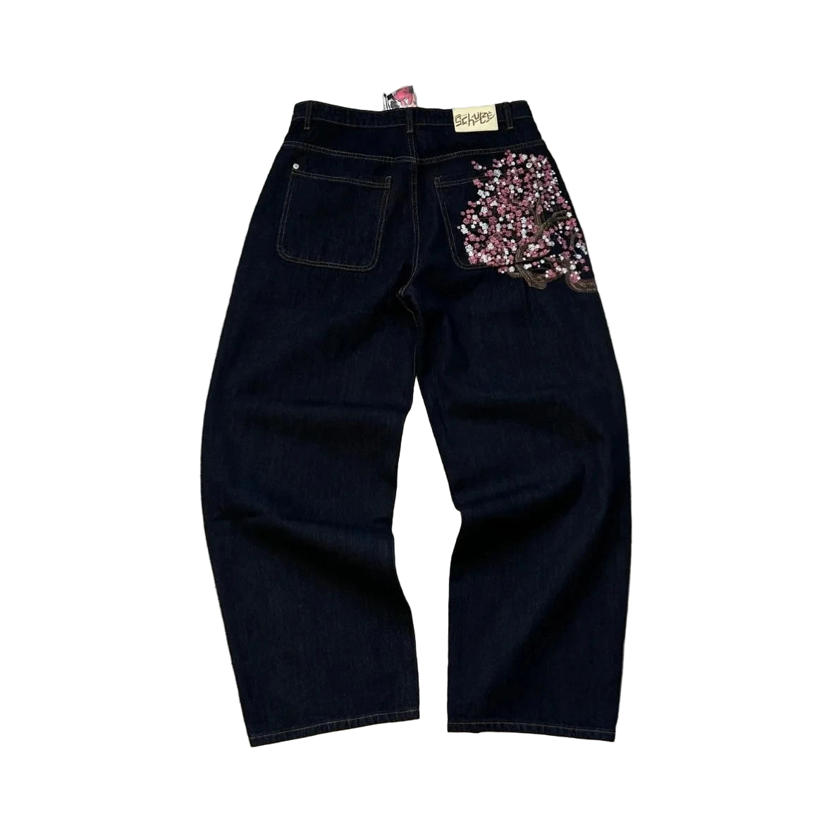 Black jeans with floral embellishments on a textured gray surface