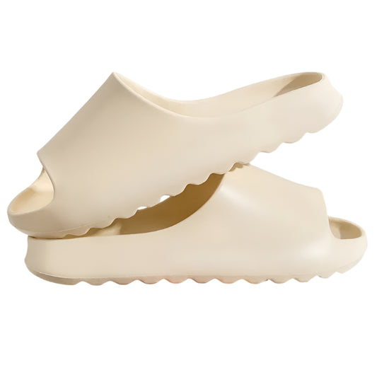 Beige open-toe shoes held by a hand against a light gray background