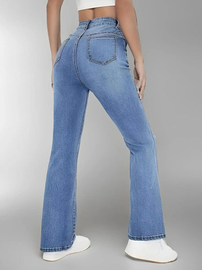 Person wearing blue flared jeans on a gray background