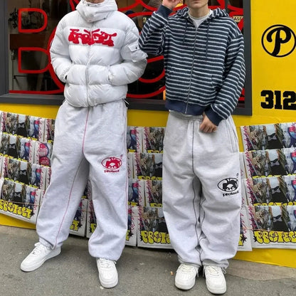 Two people wearing matching outfits in front of a store with colorful signage.