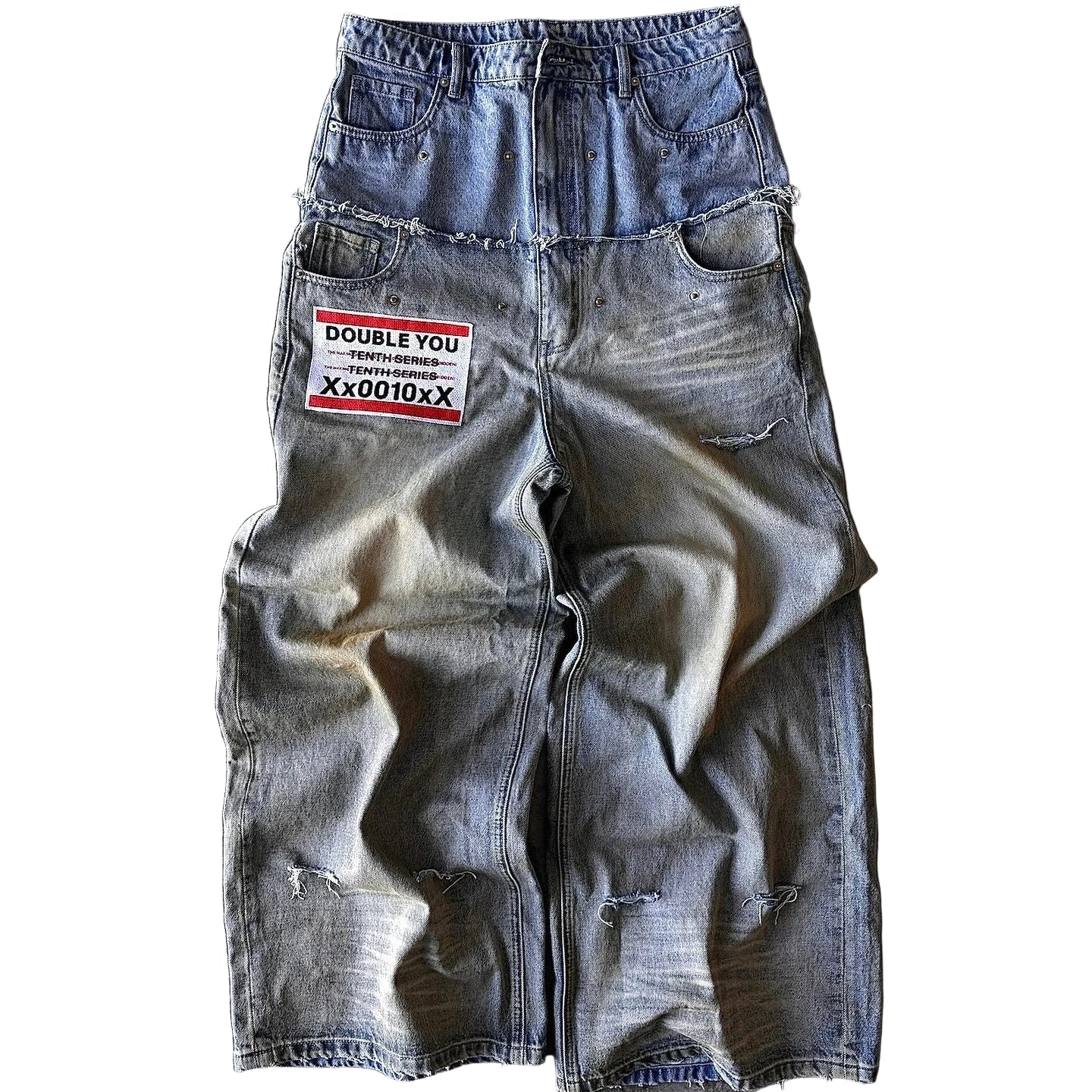 Distressed denim shorts with a patch on a concrete surface