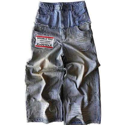 Distressed denim shorts with a patch on a concrete surface