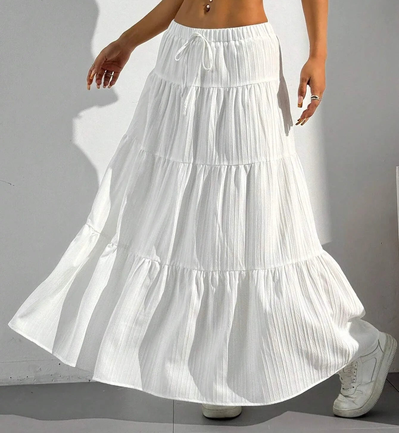 White tiered skirt worn by a person on a plain background