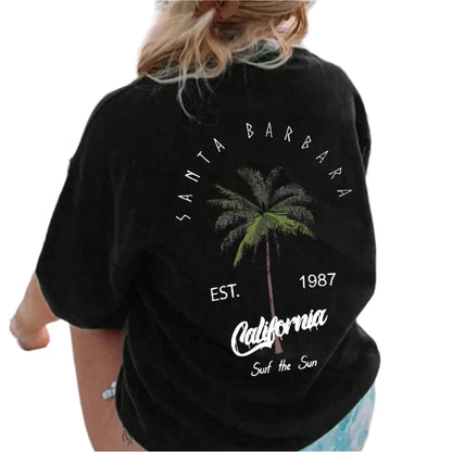 Person wearing a black t-shirt with 'Santa Barbara, California' text and palm tree graphic, standing on a boat.