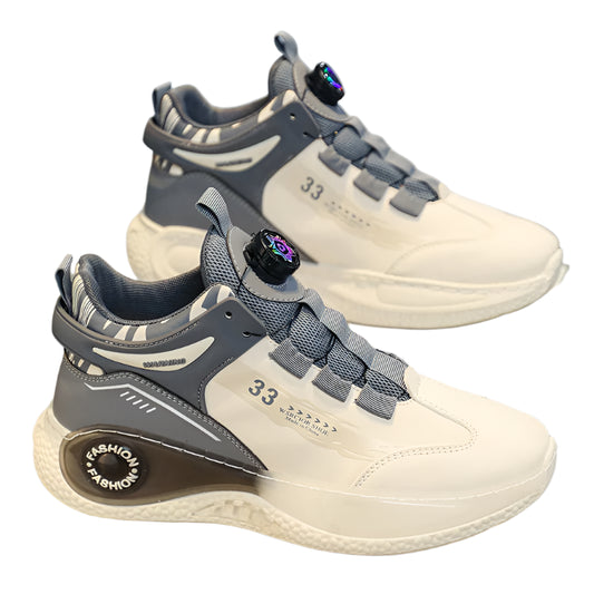 Pair of gray and beige sneakers on a reflective surface with a blurred background