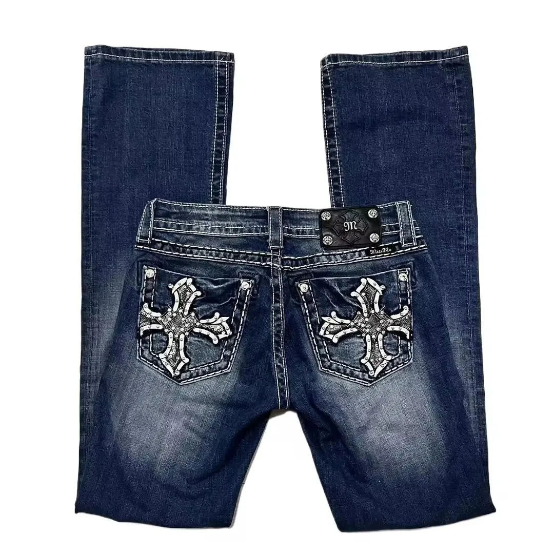 Blue jeans with decorative cross patterns on a white background