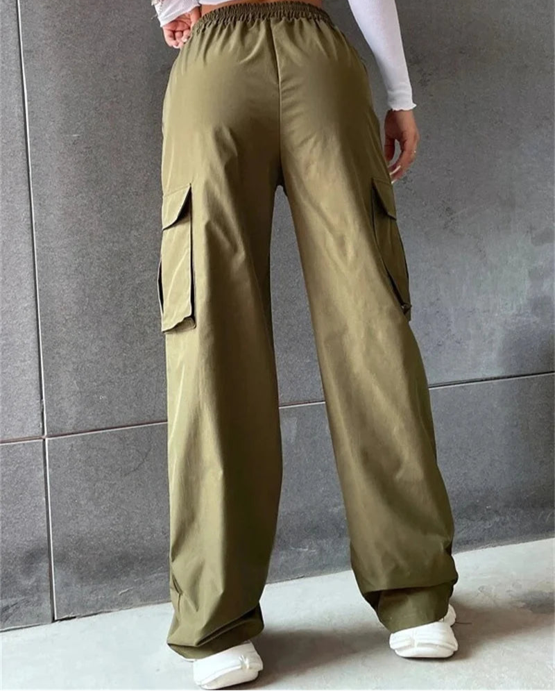 Person wearing olive green cargo pants against a gray tiled wall.