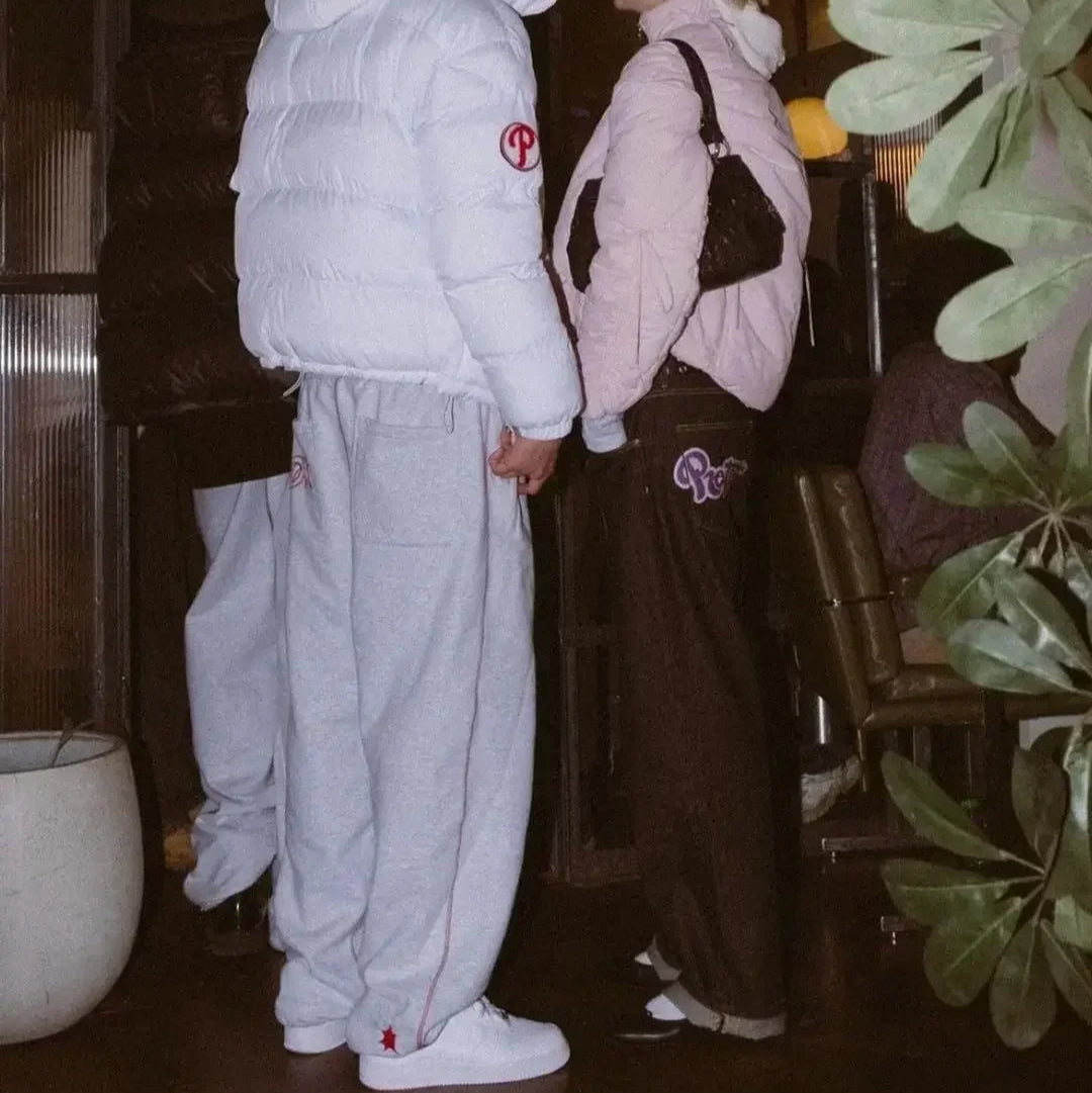 Two people wearing matching outfits with a logo in an indoor setting.