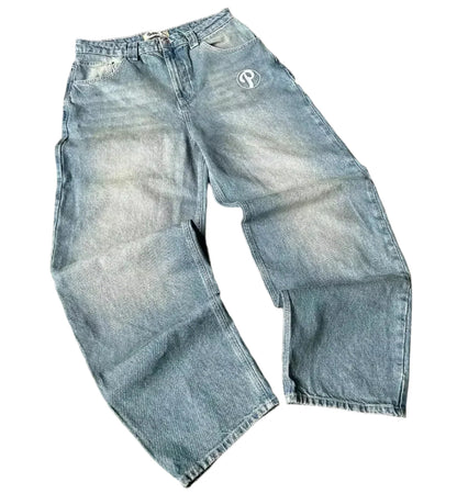 Blue jeans with a brand logo on a gray surface