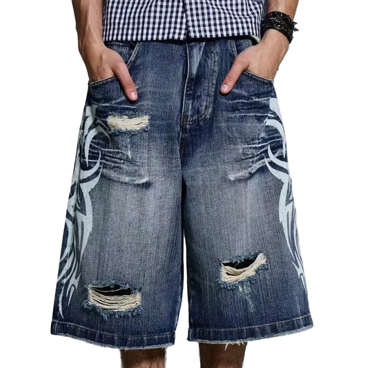 Person wearing ripped denim shorts with white graphics and Adidas boots on a plain background