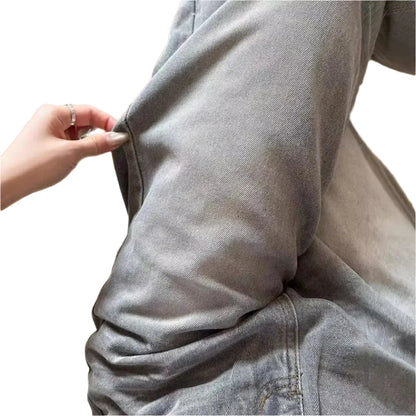 Person wearing a gray hoodie with a wooden floor background