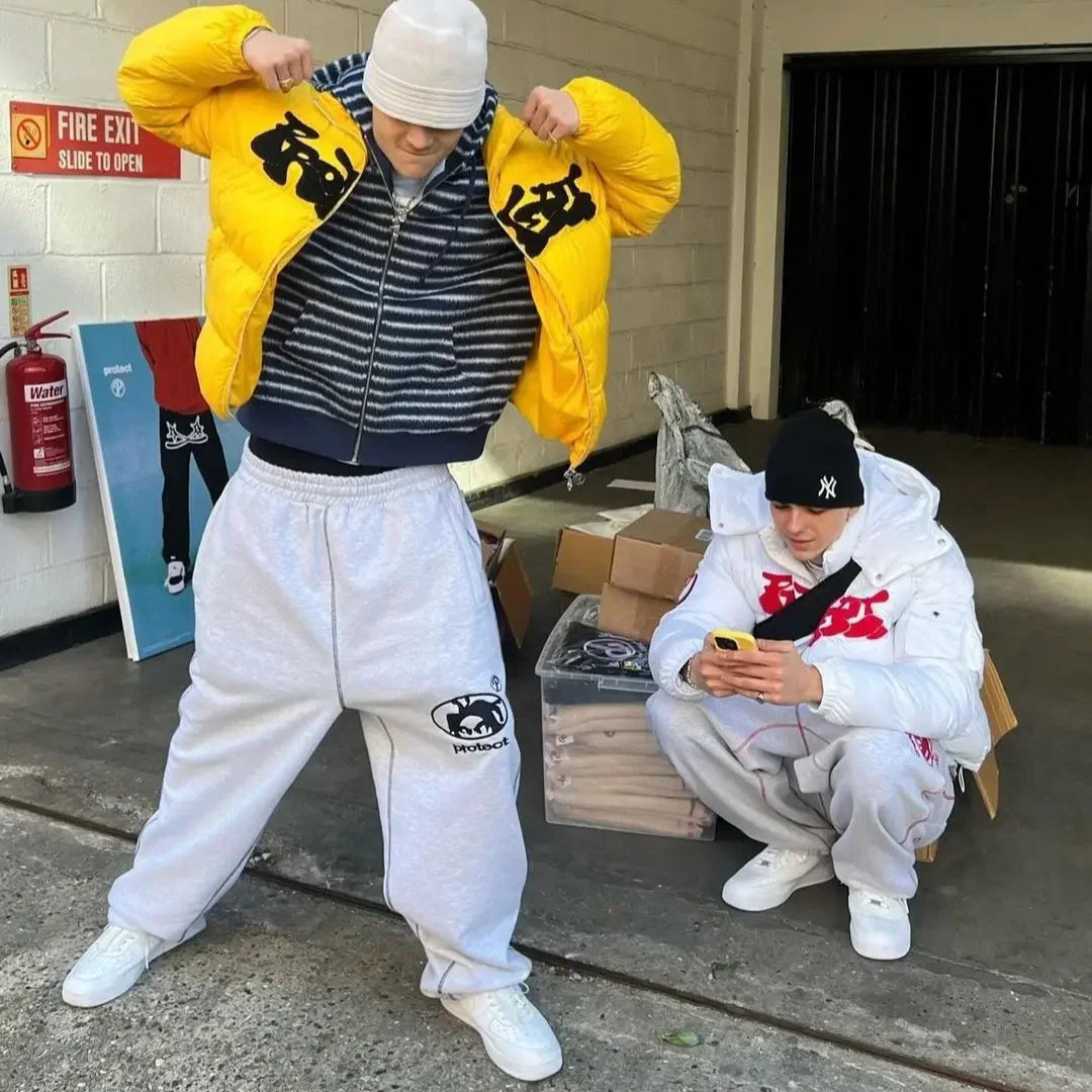 Two people in streetwear outfits in an urban setting