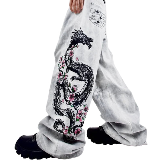 White pants with dragon and floral design worn by a person on a white background