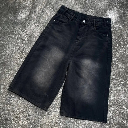 Black denim shorts on a textured gray surface