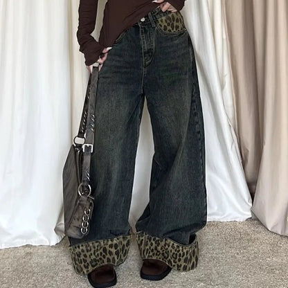 Person wearing a brown off-shoulder top, wide-leg jeans, and leopard print shoes with a handbag.