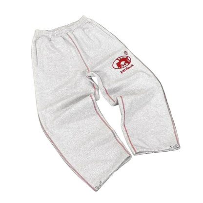 White protective pants with a red logo on a gray surface