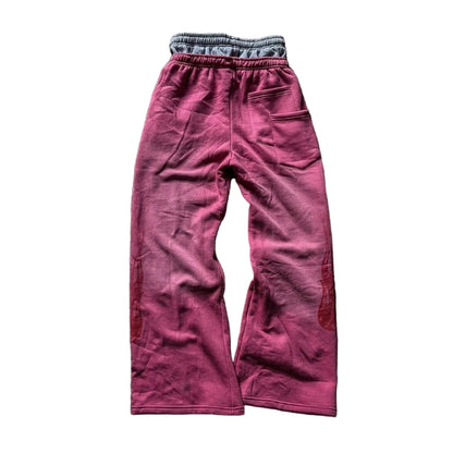 Pink sweatpants on a textured gray surface