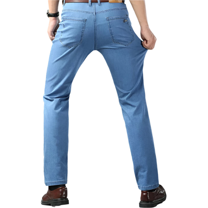 Person wearing blue jeans with a gray background