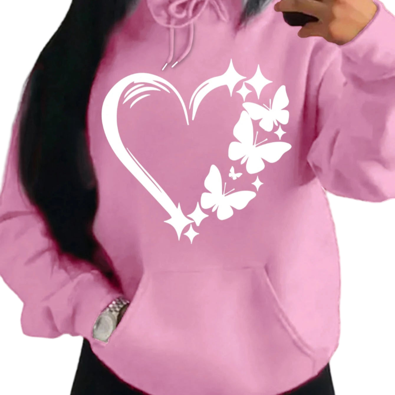 Pink hoodie with a heart and butterfly design worn by a person.
