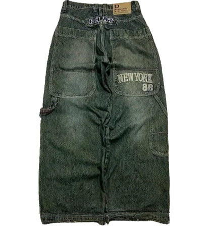 Green denim shorts with branding on a white background