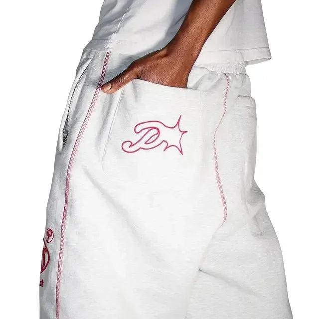 White pants with red stitching and a logo on a white background