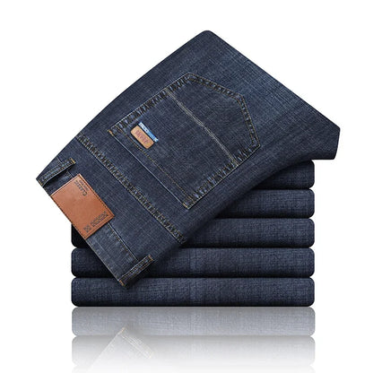 Stack of folded blue jeans with a brand label on a white background