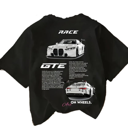 Black t-shirt with car graphics and text on a wooden surface