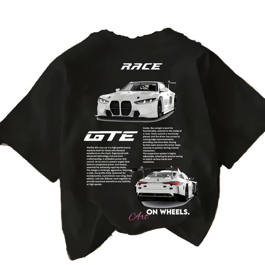 Black t-shirt with car graphics and text on a wooden surface