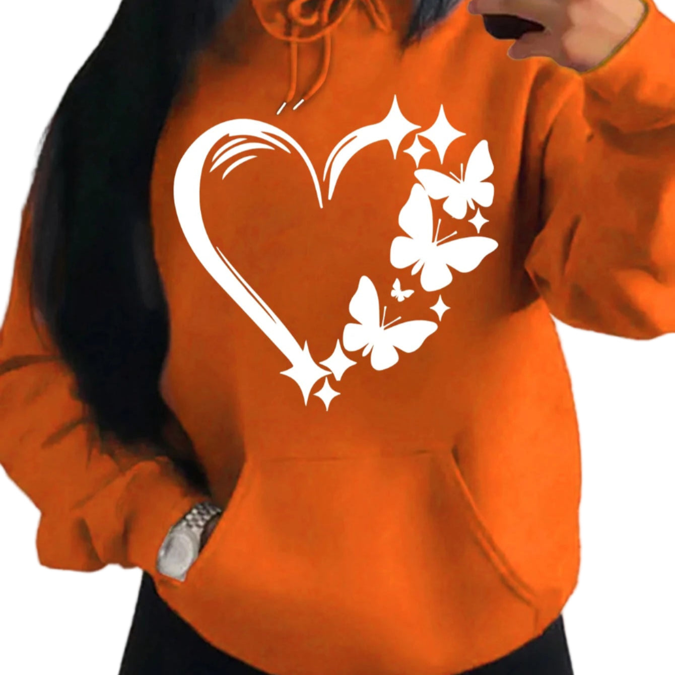 Orange hoodie with a heart and butterfly design worn by a person.