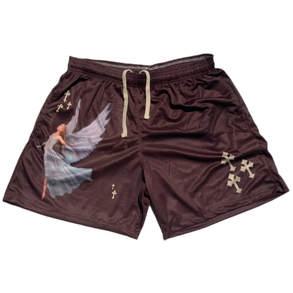 Brown shorts with angel design and cross patterns on a gray surface