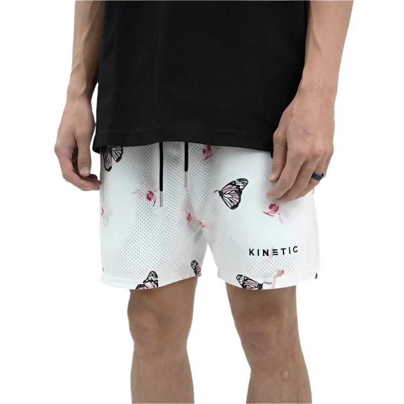 Person wearing a black top and white shorts with butterfly pattern on a white background